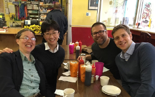 Image of faculty smiling at a restaurant
