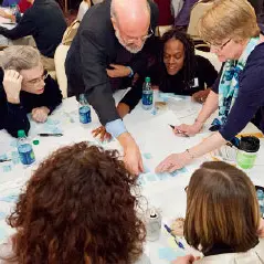 People engaging with papers on a table