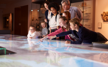 Image of children pointing to a screen