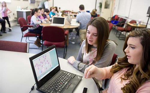 Image of students talking in front of computer