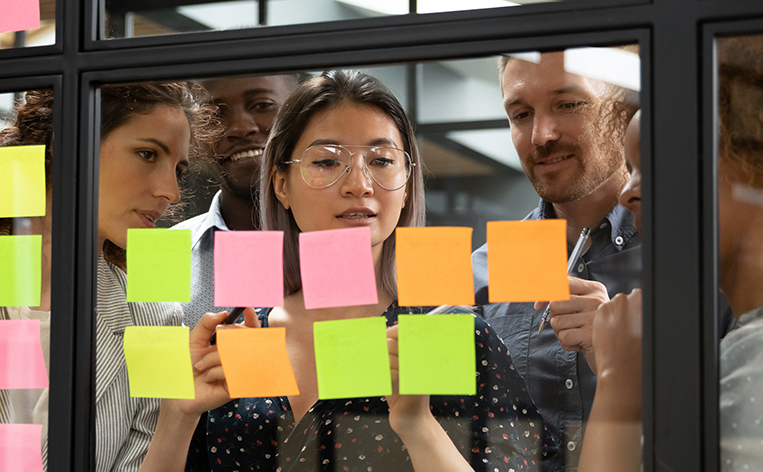 Team working together with post-it notes to organize a plan
