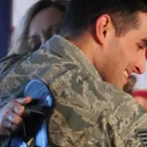 Military person hugging woman