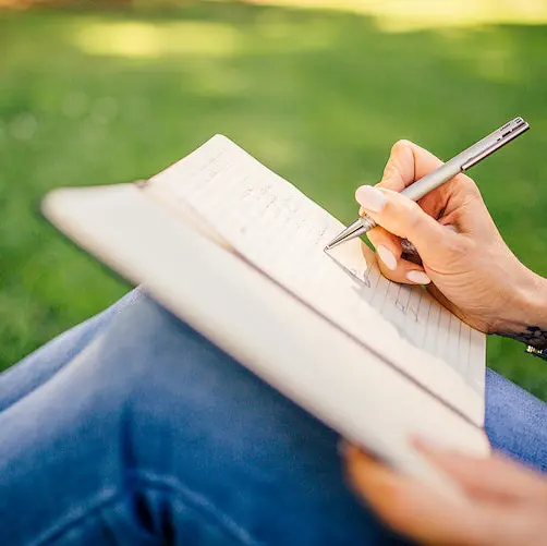 Someone writing outdoors